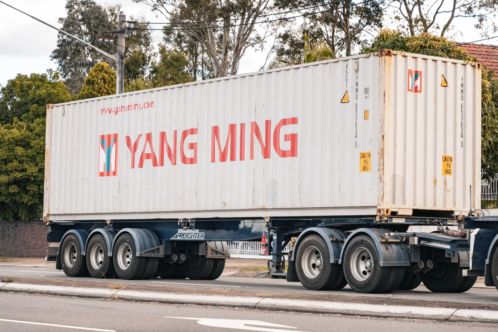 Shipping container from an Asian line on a truck trailer on a Sydney road, stock heading to an importer warehouse