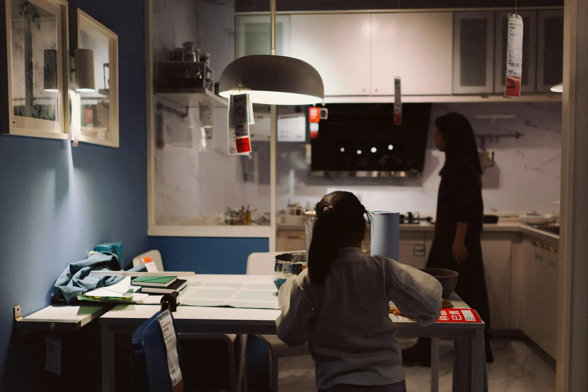 Side hustler working on a laptop at the kitchen bench in the evening