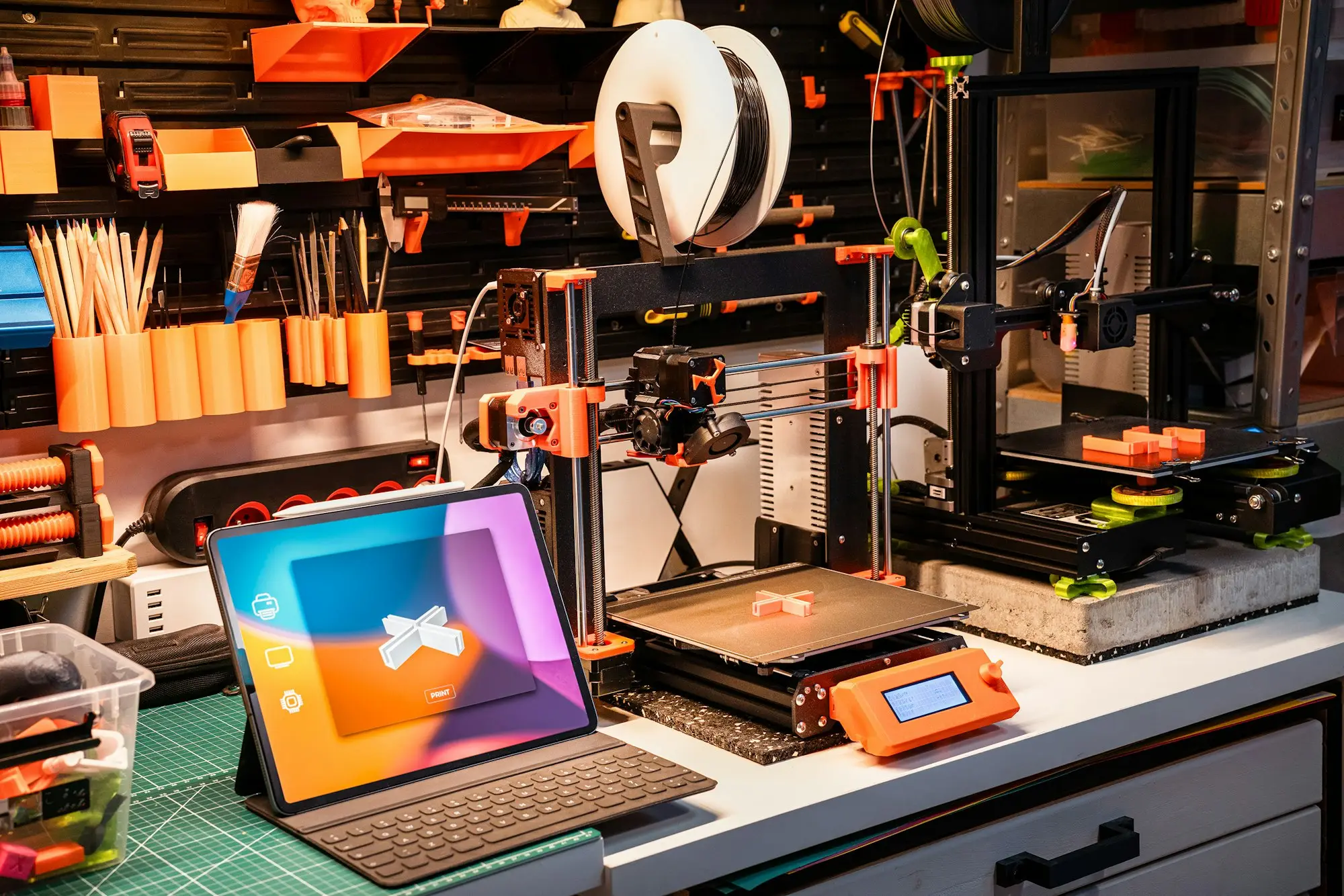Studio workbench with a 3D printer, tools and a tablet